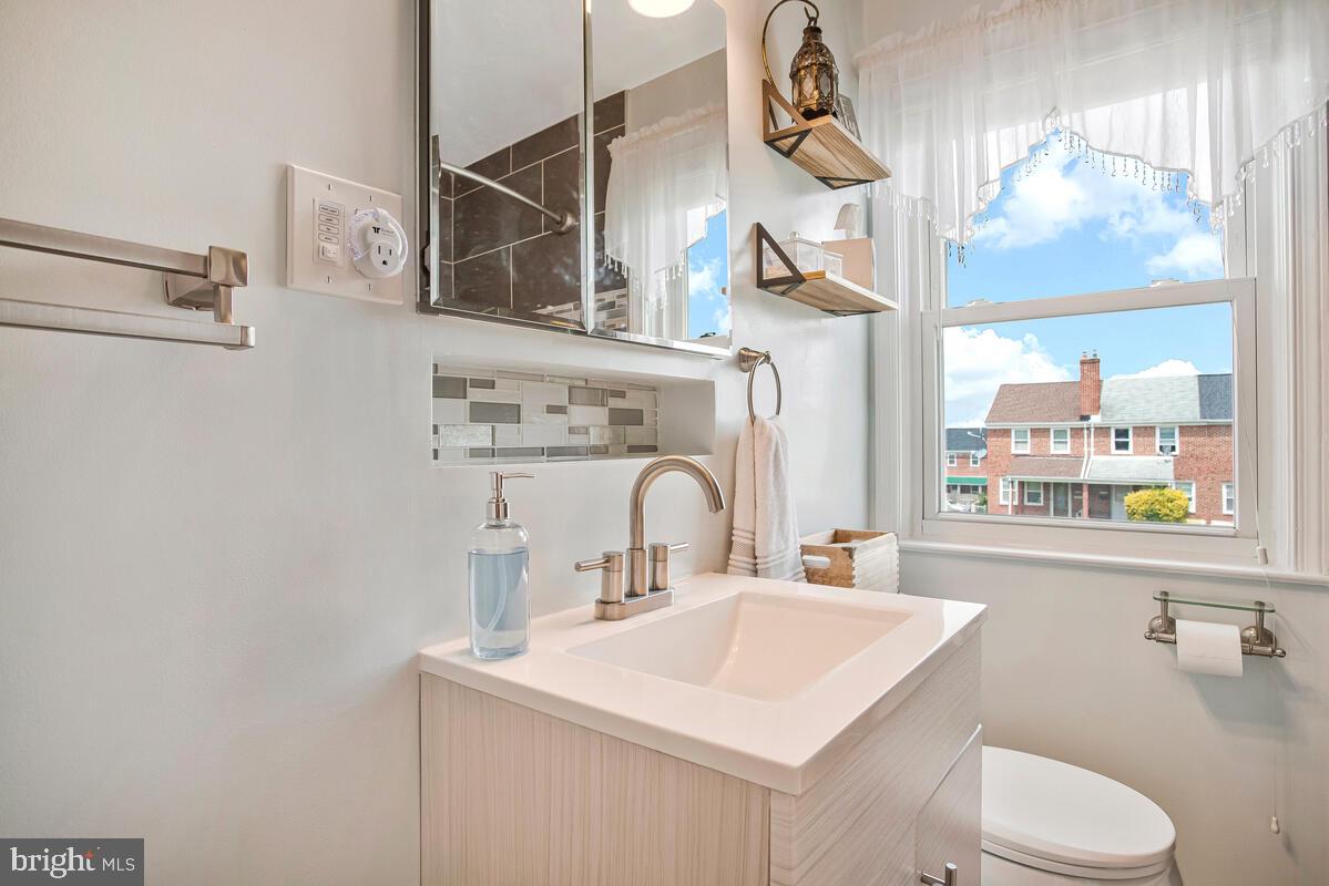 7215 Conley Street Baltimore, MD 21224 - Photo 21 of 38 a bathroom with a sink vanity mirror and toilet