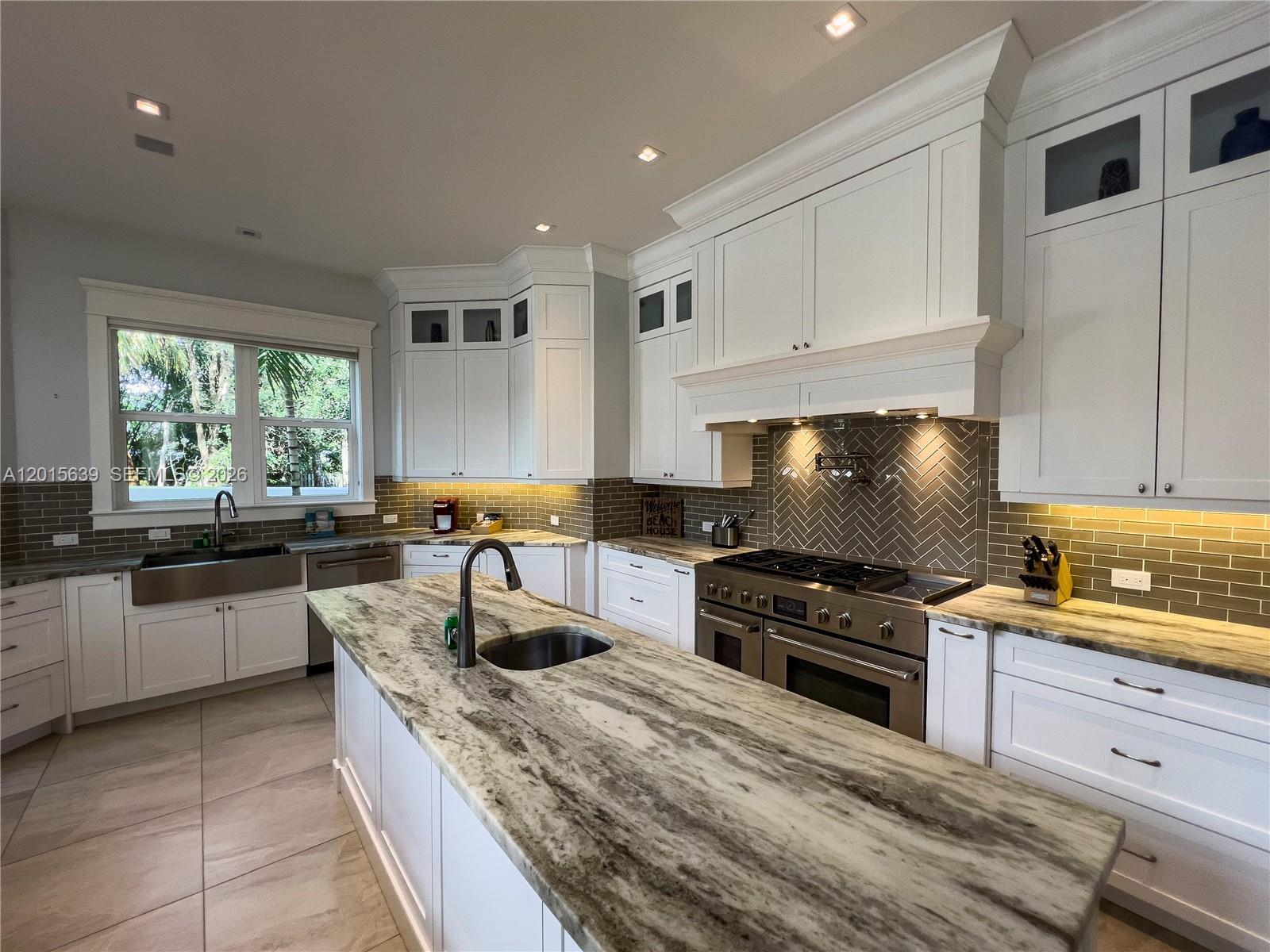 545 Southwest Indianola Street Stuart, FL 34994 - Photo 8 of 64 a kitchen with kitchen island granite countertop a sink a counter top space appliances and cabinets