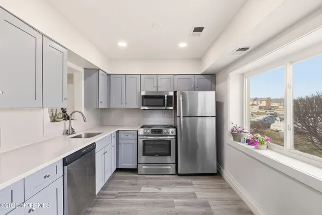 a kitchen with a sink stainless steel appliances and cabinets