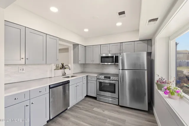 a kitchen with a sink stainless steel appliances and cabinets
