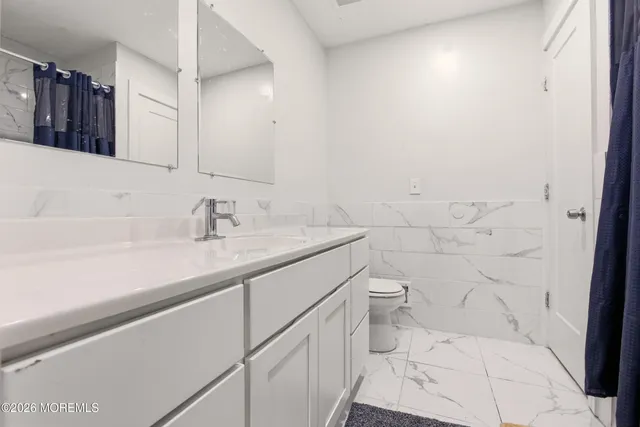 a bathroom with a sink a toilet and mirror