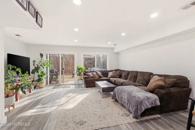 a living room with furniture a flat screen tv and a potted plant