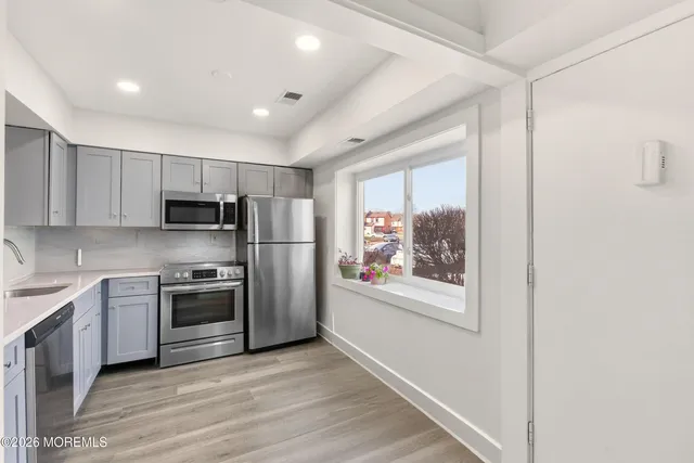 a kitchen with stainless steel appliances granite countertop a refrigerator and a stove top oven