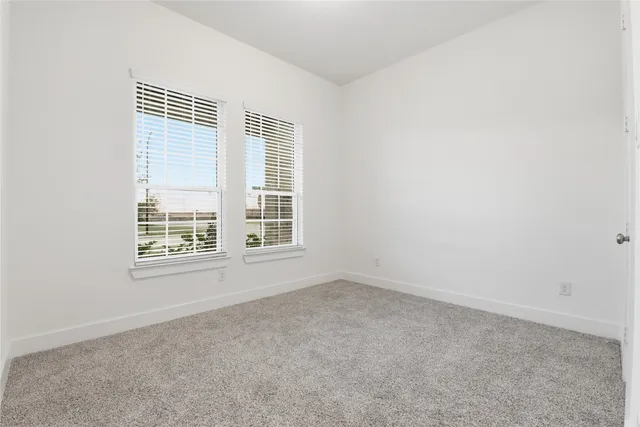 an empty room with fan and windows