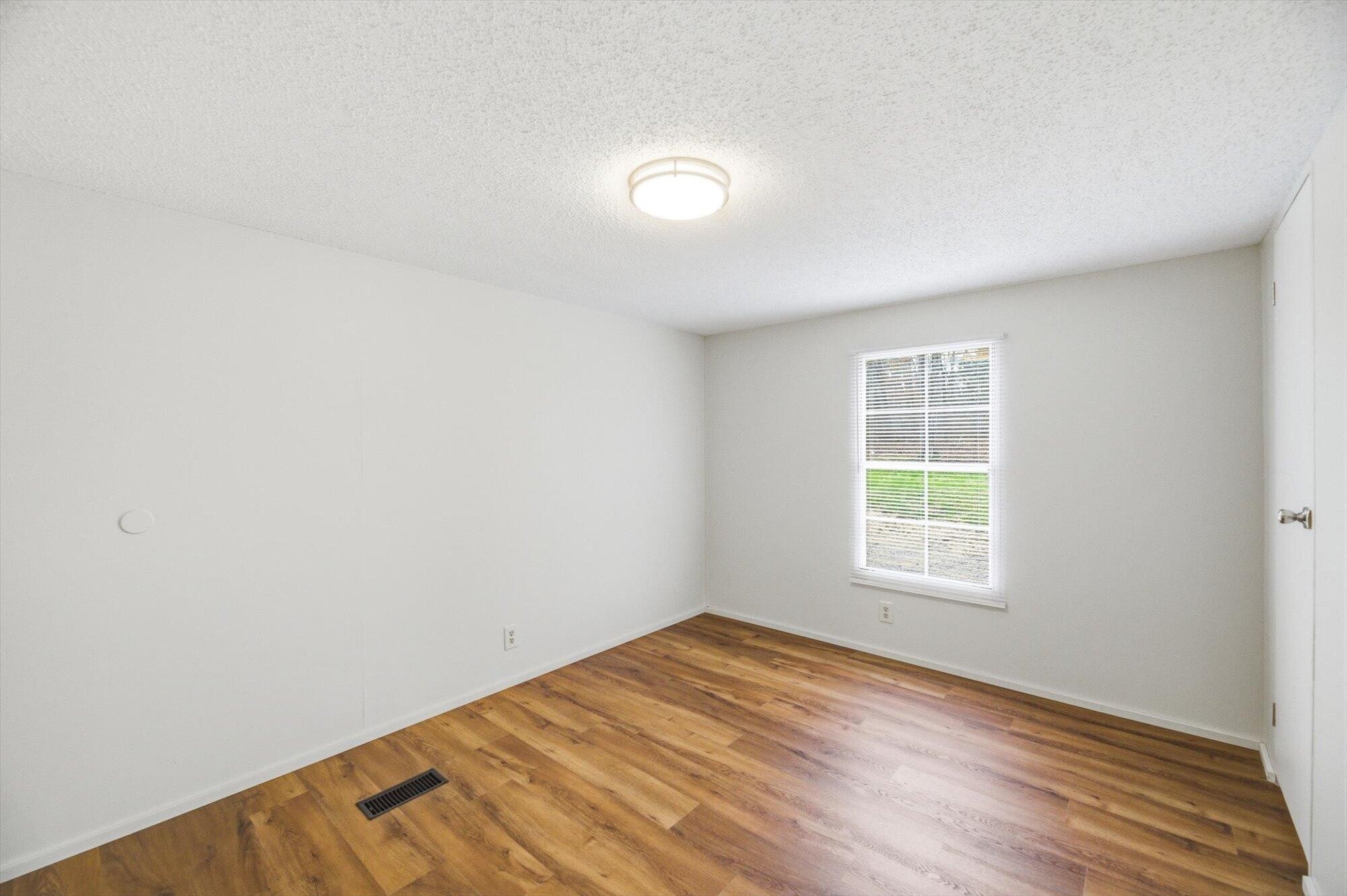 64 County Road 100 Decatur, TN 37322 - Photo 16 of 43 an empty room with wooden floor and windows