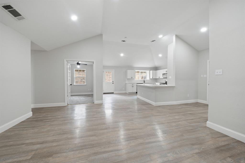 310 Valley Spring Drive Arlington, TX 76018 - Photo 10 of 24 Spacious room featuring wood-finish flooring, vaulted ceilings, and recessed lighting