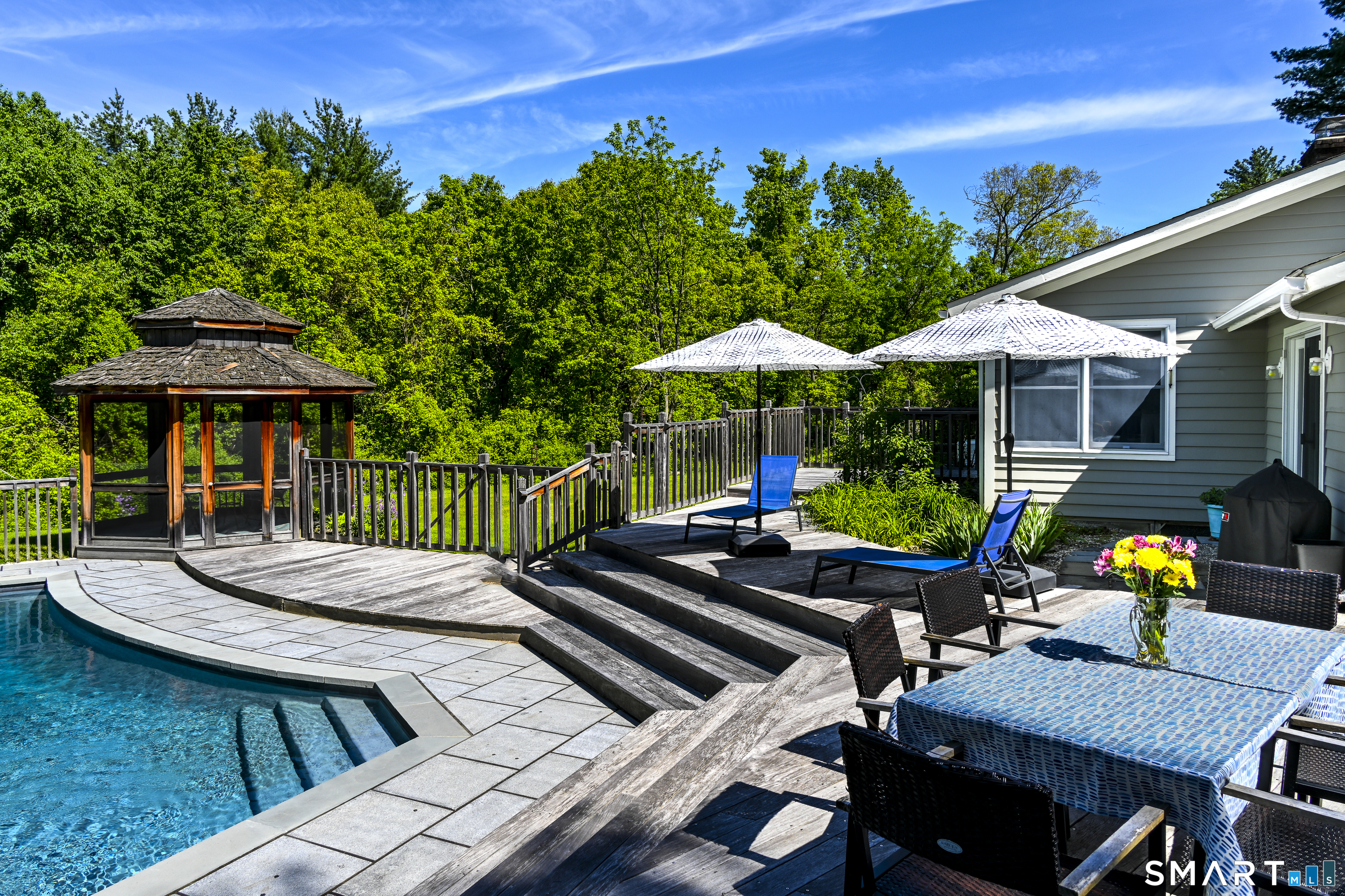 7 Chimney Rock Road Kent, CT 06757 - Photo 24 of 35 a view of a patio with couches table and chairs under an umbrella with a small yard