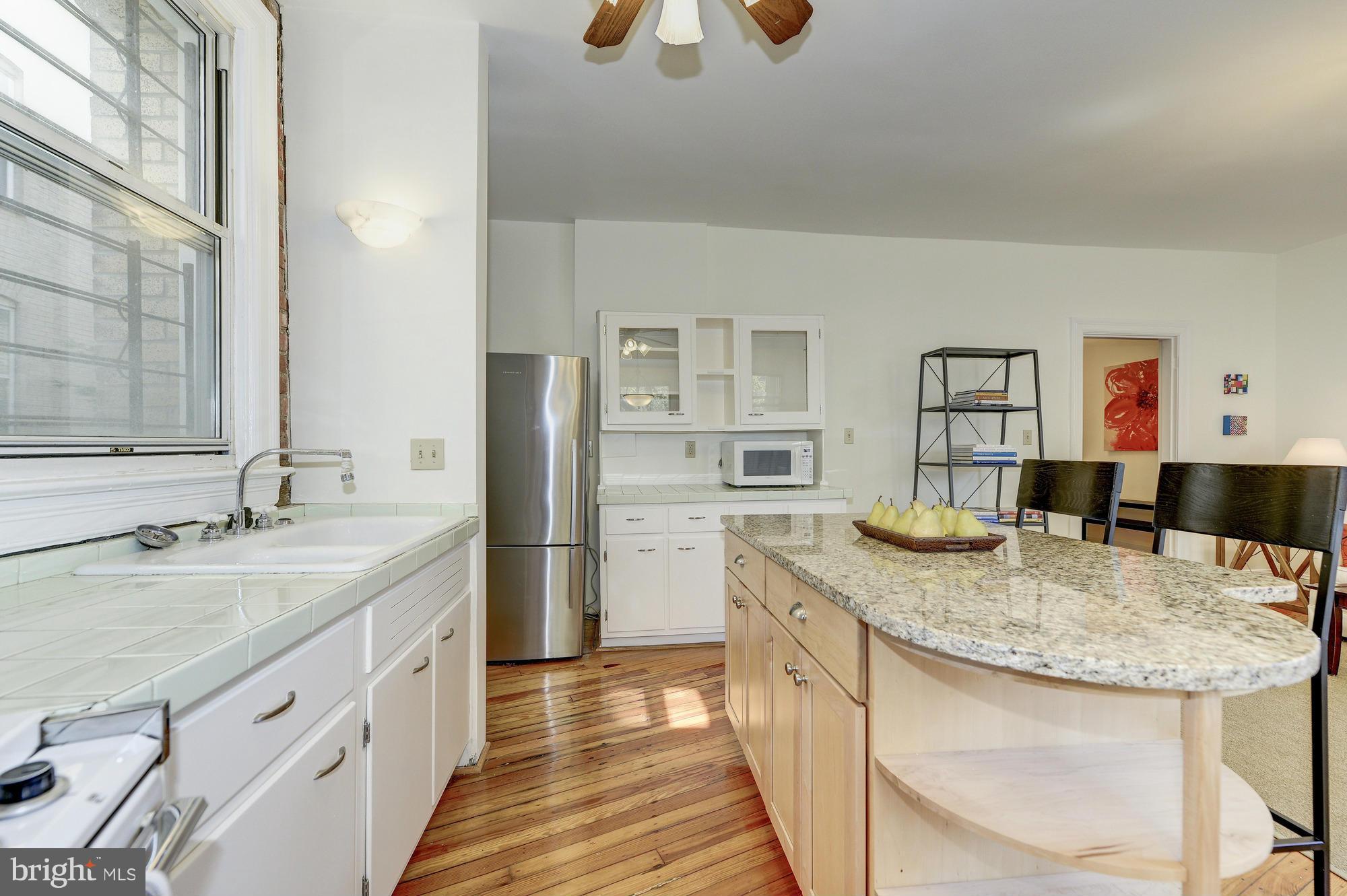 2605 Adams Mill Road Northwest, Unit 2 Washington, DC 20009 - Photo 13 of 30 a kitchen with stainless steel appliances granite countertop a sink and a refrigerator