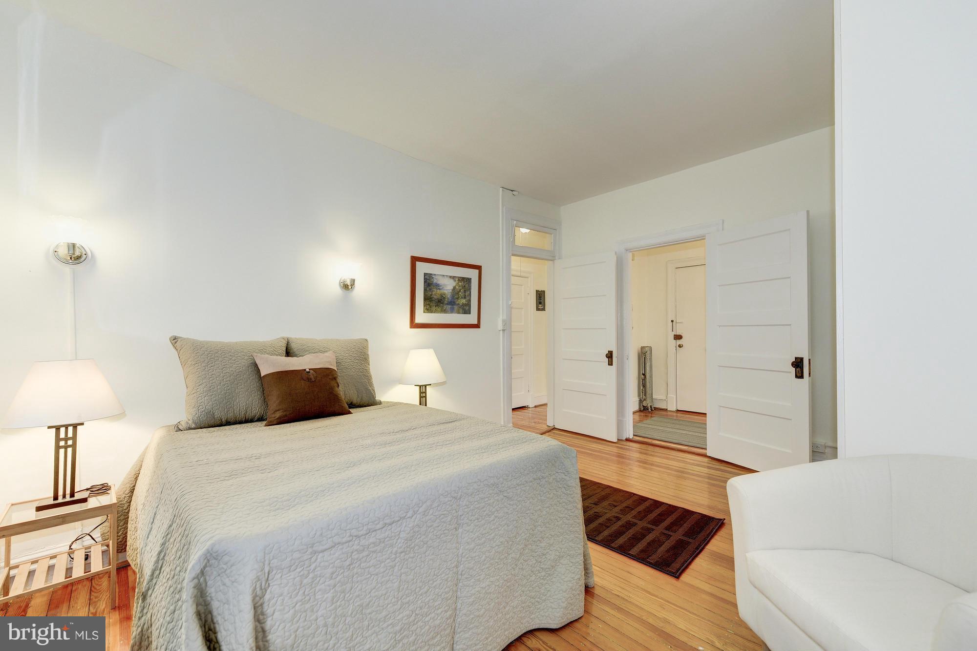 2605 Adams Mill Road Northwest, Unit 2 Washington, DC 20009 - Photo 19 of 30 a spacious bedroom with a bed and a lamp