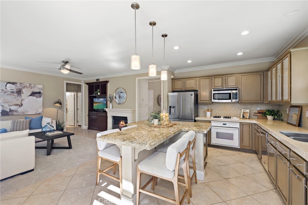 4 Celestine Circle Ladera Ranch, CA 92694 - Photo 9 of 39 a kitchen with kitchen island granite countertop wooden cabinets and refrigerator