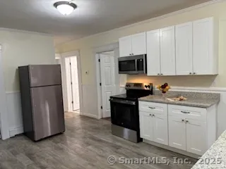 a kitchen with stainless steel appliances granite countertop a refrigerator sink and stove