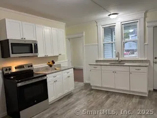 a kitchen with stainless steel appliances granite countertop a stove a sink and a microwave