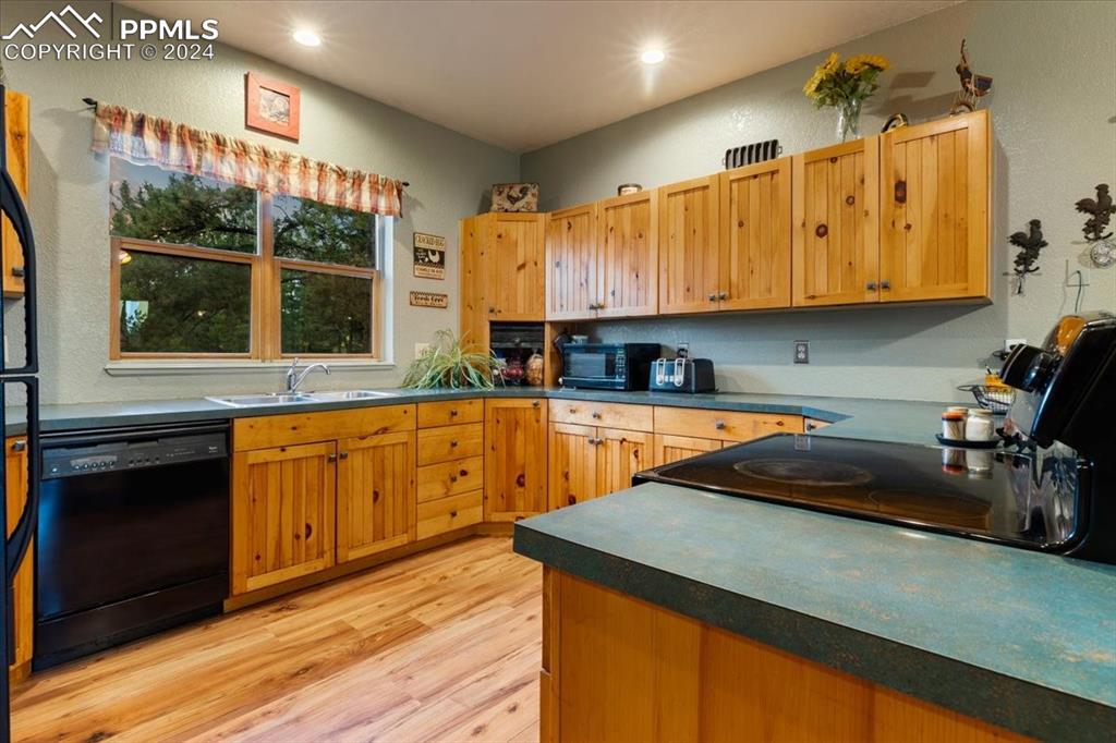 123 Maroon Lake Circle Divide, CO 80814 - Photo 17 of 47 a kitchen with stainless steel appliances granite countertop a sink a stove and a wooden cabinets