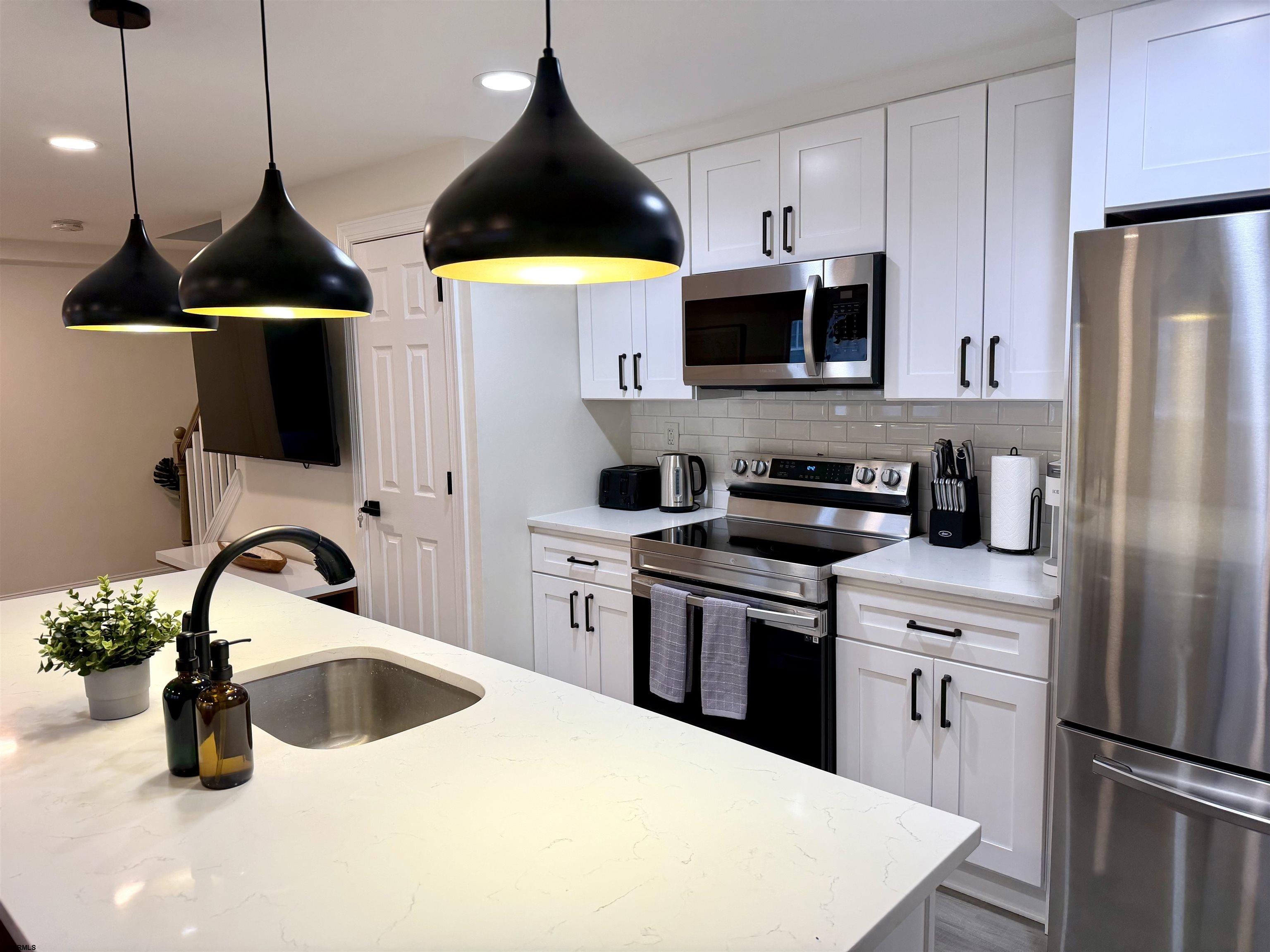 110 West Buttercup Road, Unit 5 Wildwood Crest, NJ 08260 - Photo 13 of 31 a kitchen with stainless steel appliances a stove a sink a microwave and refrigerator