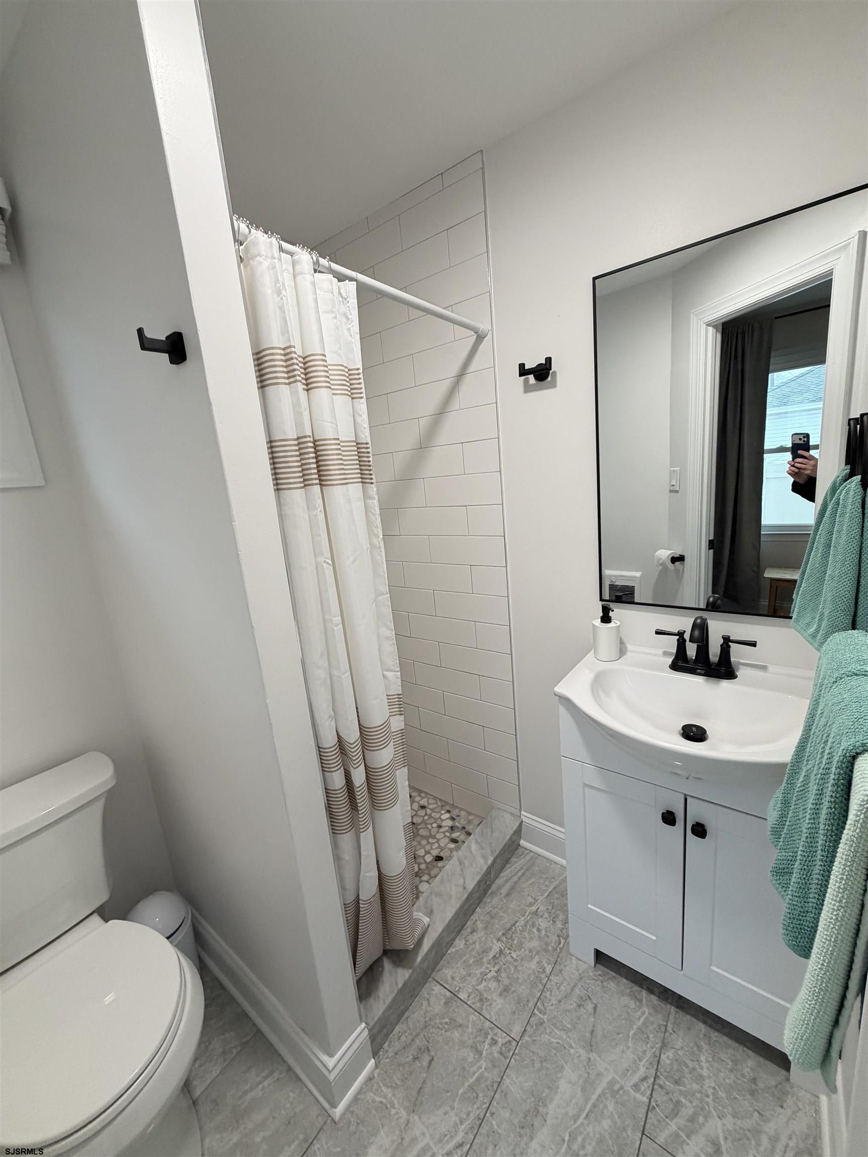 110 West Buttercup Road, Unit 5 Wildwood Crest, NJ 08260 - Photo 24 of 31 a bathroom with a sink a toilet a mirror and shower