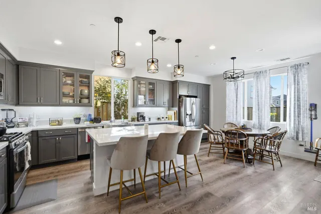 a kitchen with stainless steel appliances granite countertop a sink a stove and a wooden floor