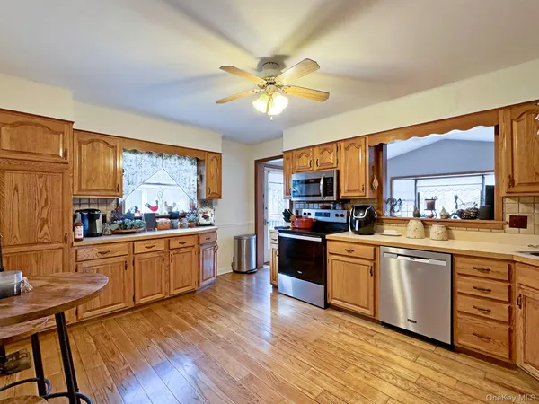 a kitchen with stainless steel appliances granite countertop wooden floors and white cabinets