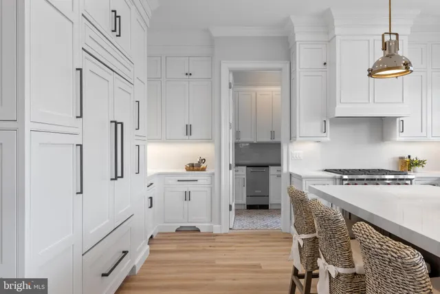 a view of a dining room and livingroom with furniture wooden floor a chandelier