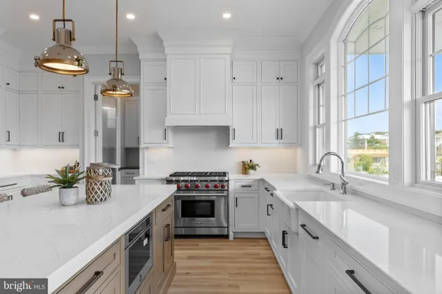 a kitchen with stainless steel appliances granite countertop a stove a refrigerator and a white cabinets