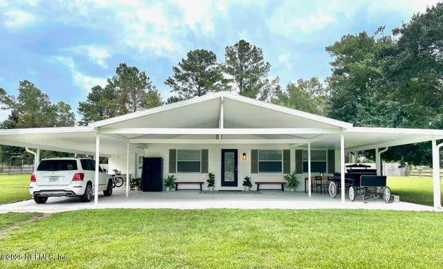 a view of a yard of the house with a patio and a yard