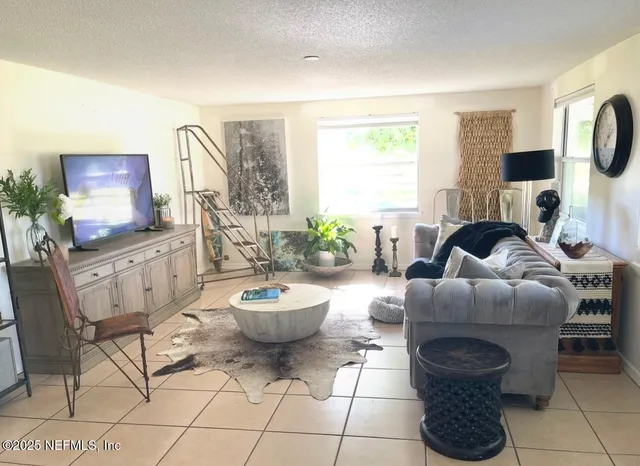 a living room with furniture a flat screen tv and a window