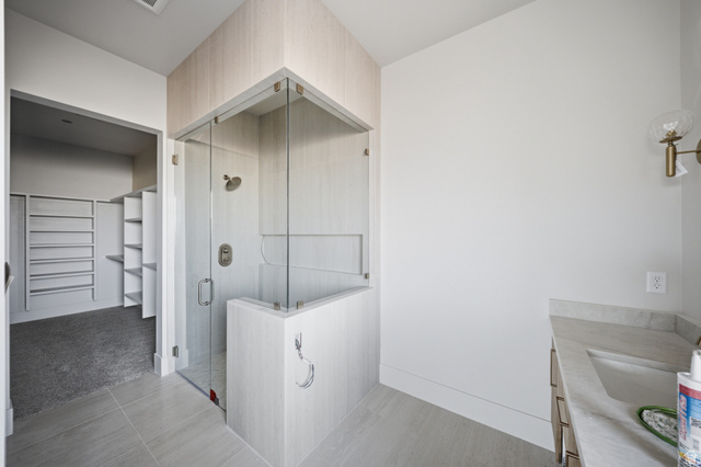 3011 East Rimrunner Drive, Unit 302 St. George, UT 84790 - Photo 23 of 45 Bathroom with vanity, a spacious closet, a shower stall, light colored carpet, and light tile patterned floors
