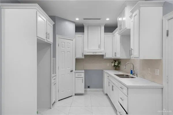 a kitchen with white cabinets and white appliances