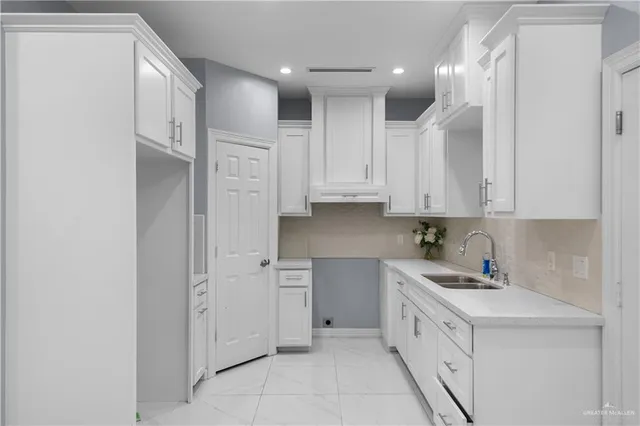 a kitchen with white cabinets and white appliances