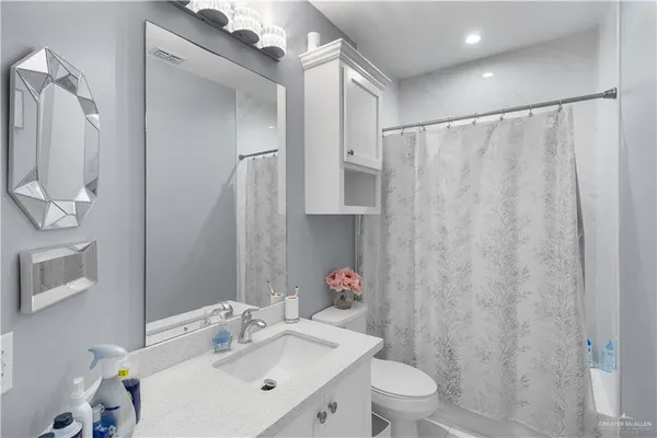a bathroom with a sink vanity mirror and toilet