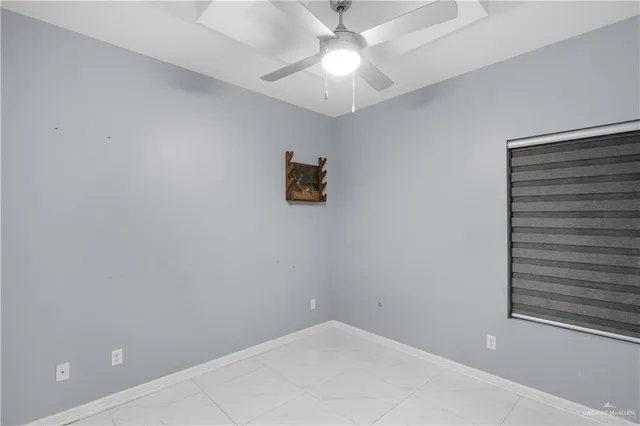 en empty room with a ceiling fan and a window