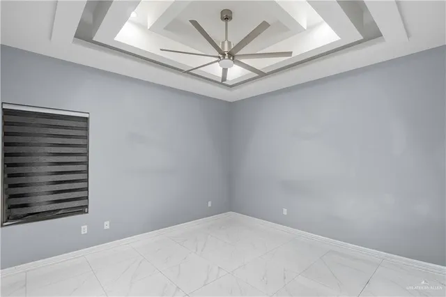 a view of a room with a ceiling fan and wooden floor