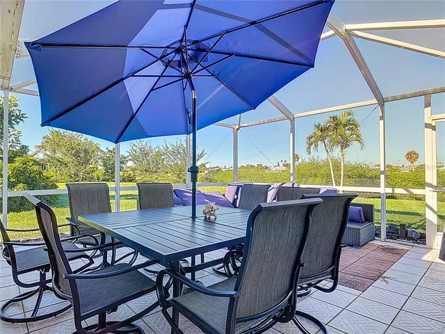 a view of an outdoor dining space with furniture and umbrella