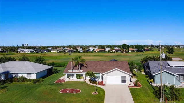 an aerial view of a house with a garden and lake view