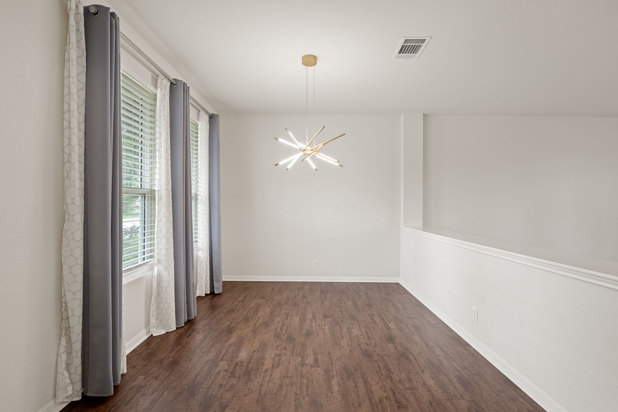8902 Magna Carta Loop, Unit 122 Austin, TX 78754 - Photo 6 of 39 A well-lit area featuring rich wood flooring and abundant natural illumination from a series of windows.