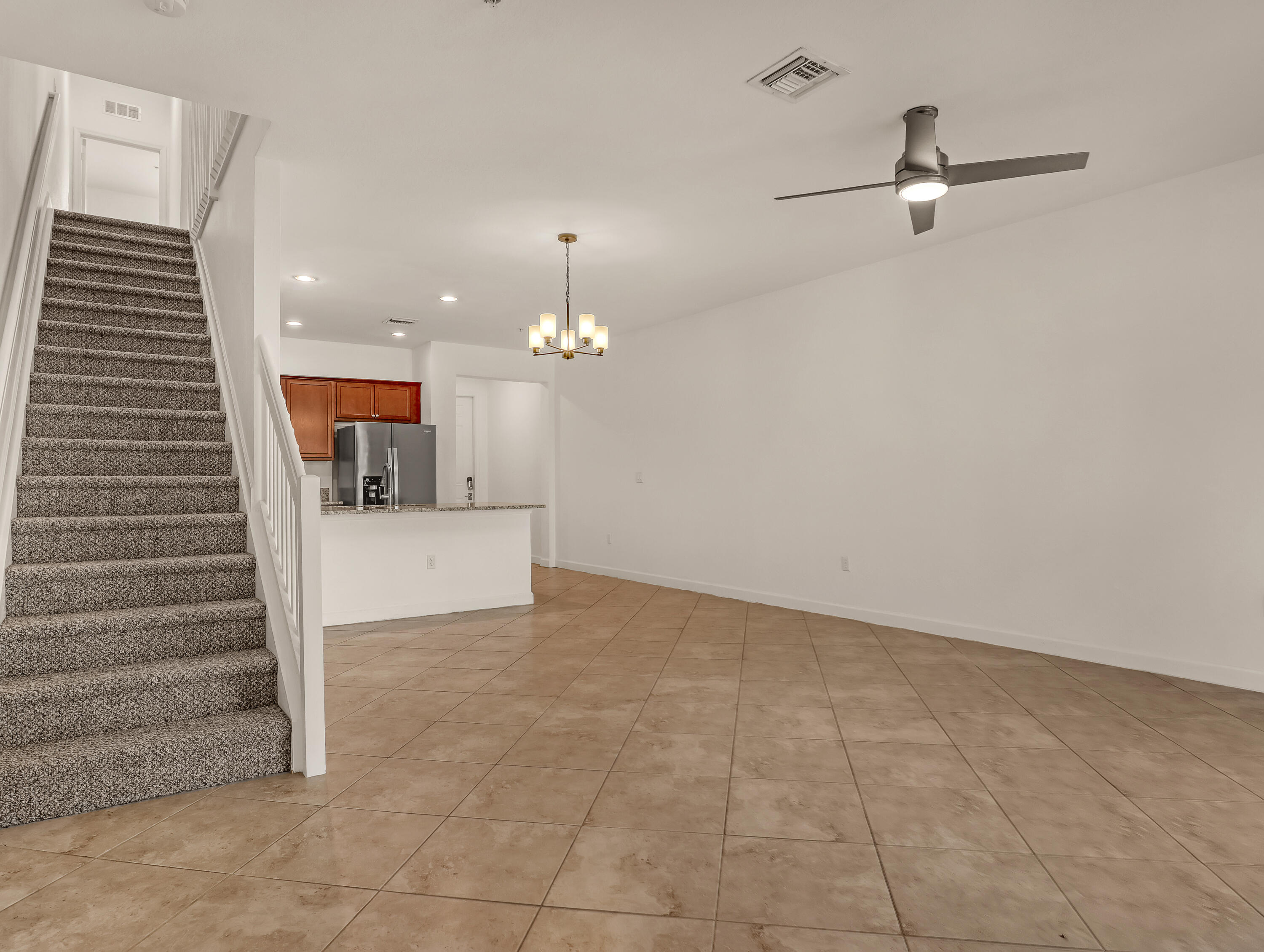 9508 Southwest Otter Lane Stuart, FL 34997 - Photo 11 of 34 wooden floor in an empty room with a ceiling fan