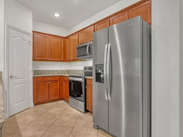 a kitchen with granite countertop cabinets stainless steel appliances and a sink