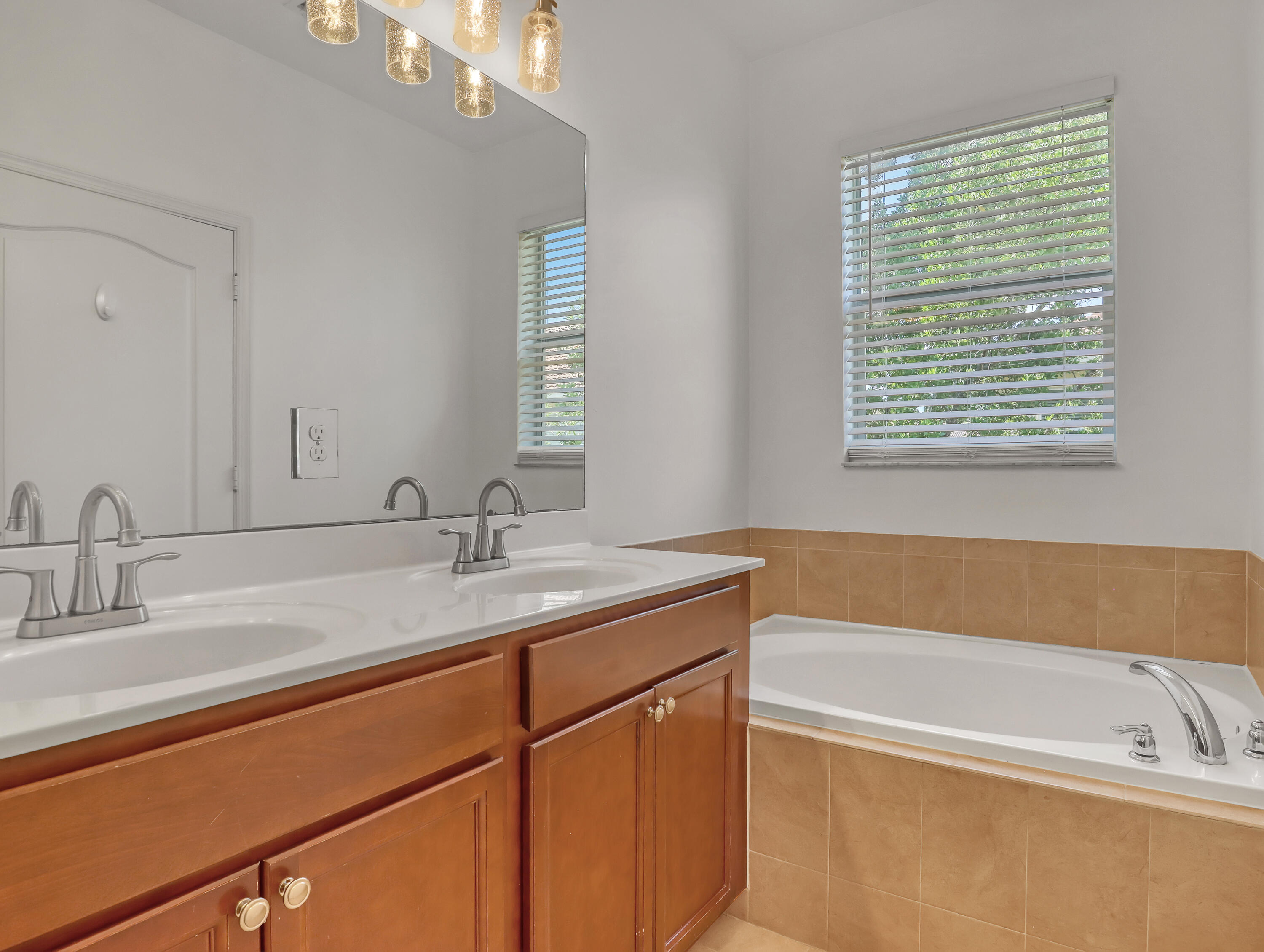 9508 Southwest Otter Lane Stuart, FL 34997 - Photo 24 of 34 a bathroom with a tub sink and mirror
