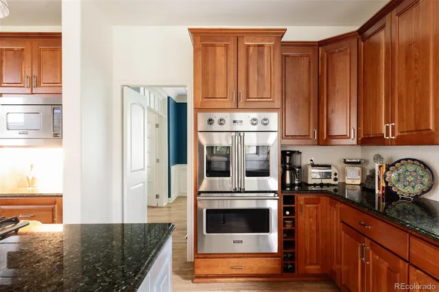 a kitchen with stainless steel appliances granite countertop a refrigerator and a stove top oven