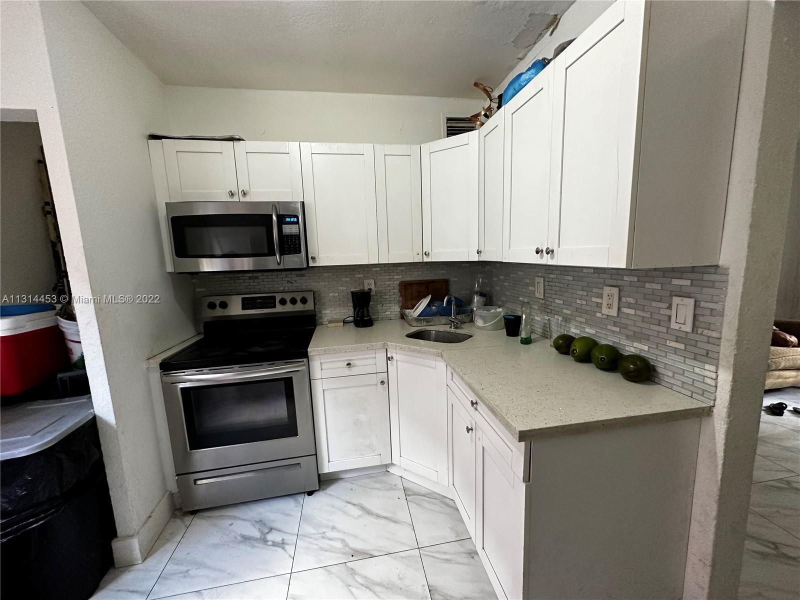 7001 Northwest 6th Avenue Miami, FL 33150 - Photo 2 of 7 a kitchen with stainless steel appliances granite countertop a sink and a stove