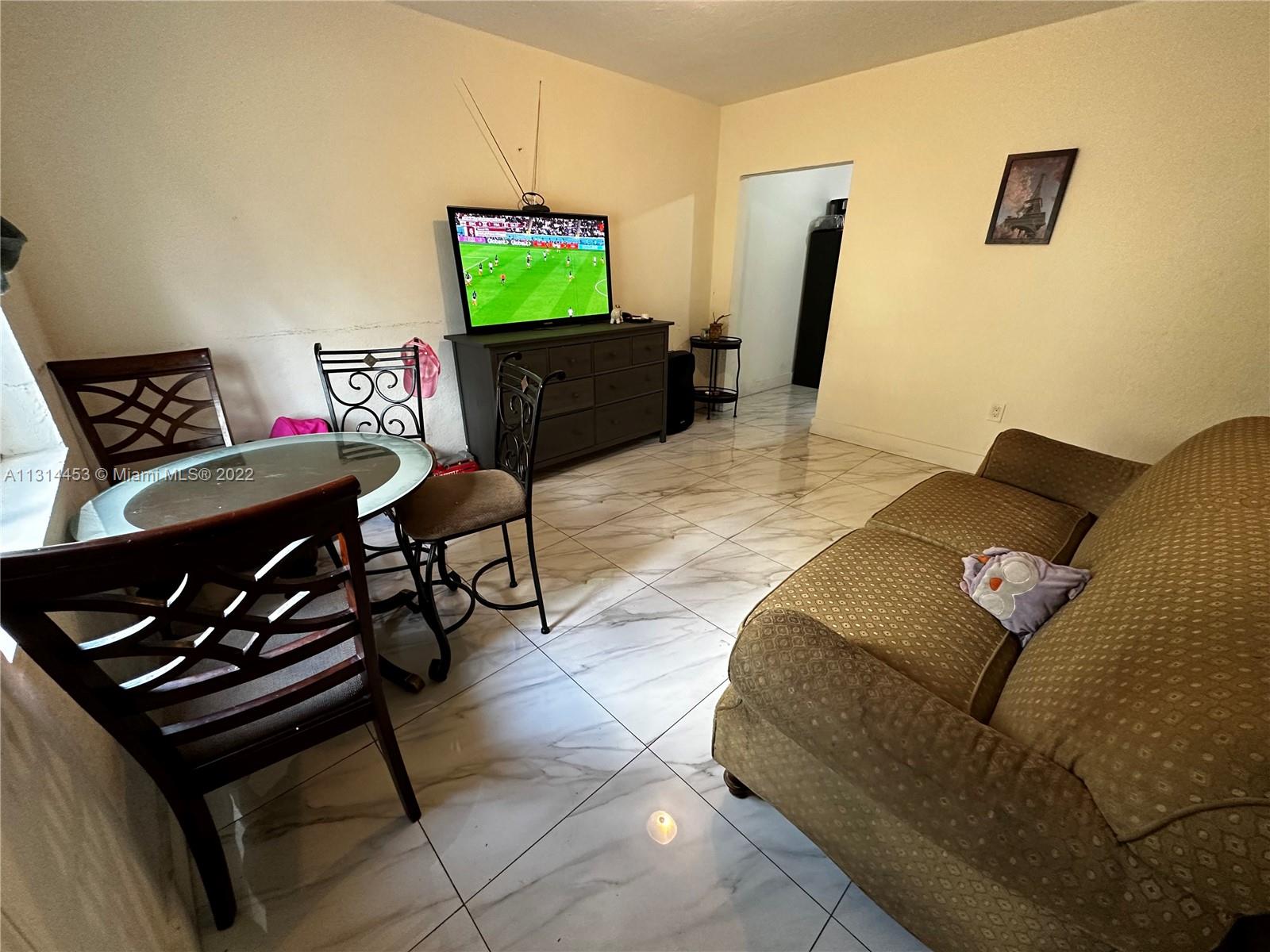 7001 Northwest 6th Avenue Miami, FL 33150 - Photo 4 of 7 a living room with furniture and a flat screen tv