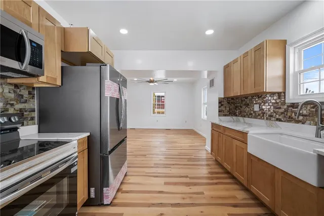 a kitchen with stainless steel appliances kitchen island granite countertop a refrigerator and a stove top oven