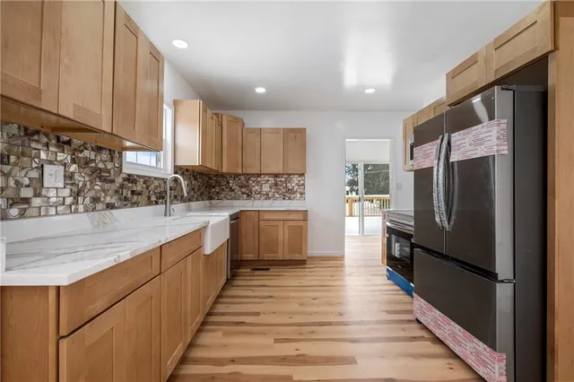 a kitchen with stainless steel appliances a refrigerator sink and cabinets