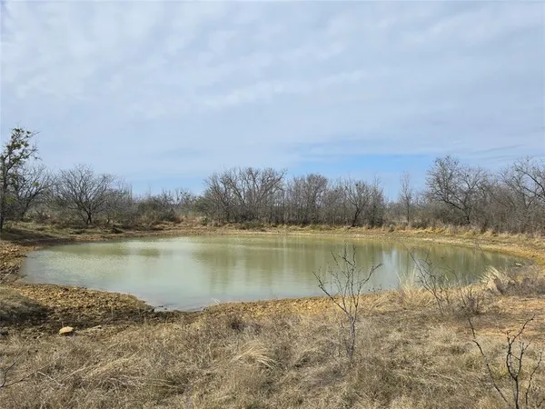 a view of a lake in between the floor and trees