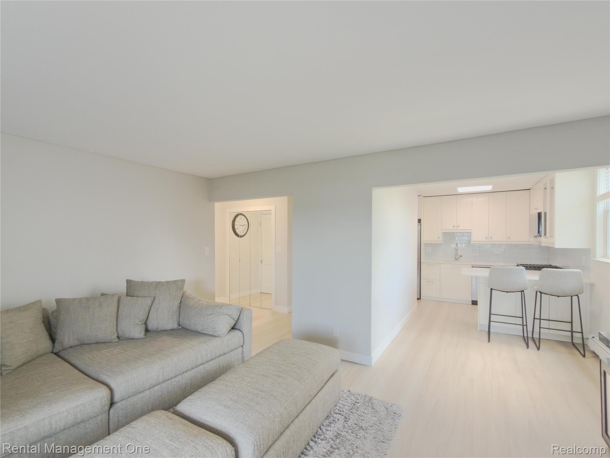1603 Cass Lake Road, Unit D Keego Harbor, MI 48320 - Photo 15 of 20 Bright living area featuring light-toned walls and wood-finish flooring