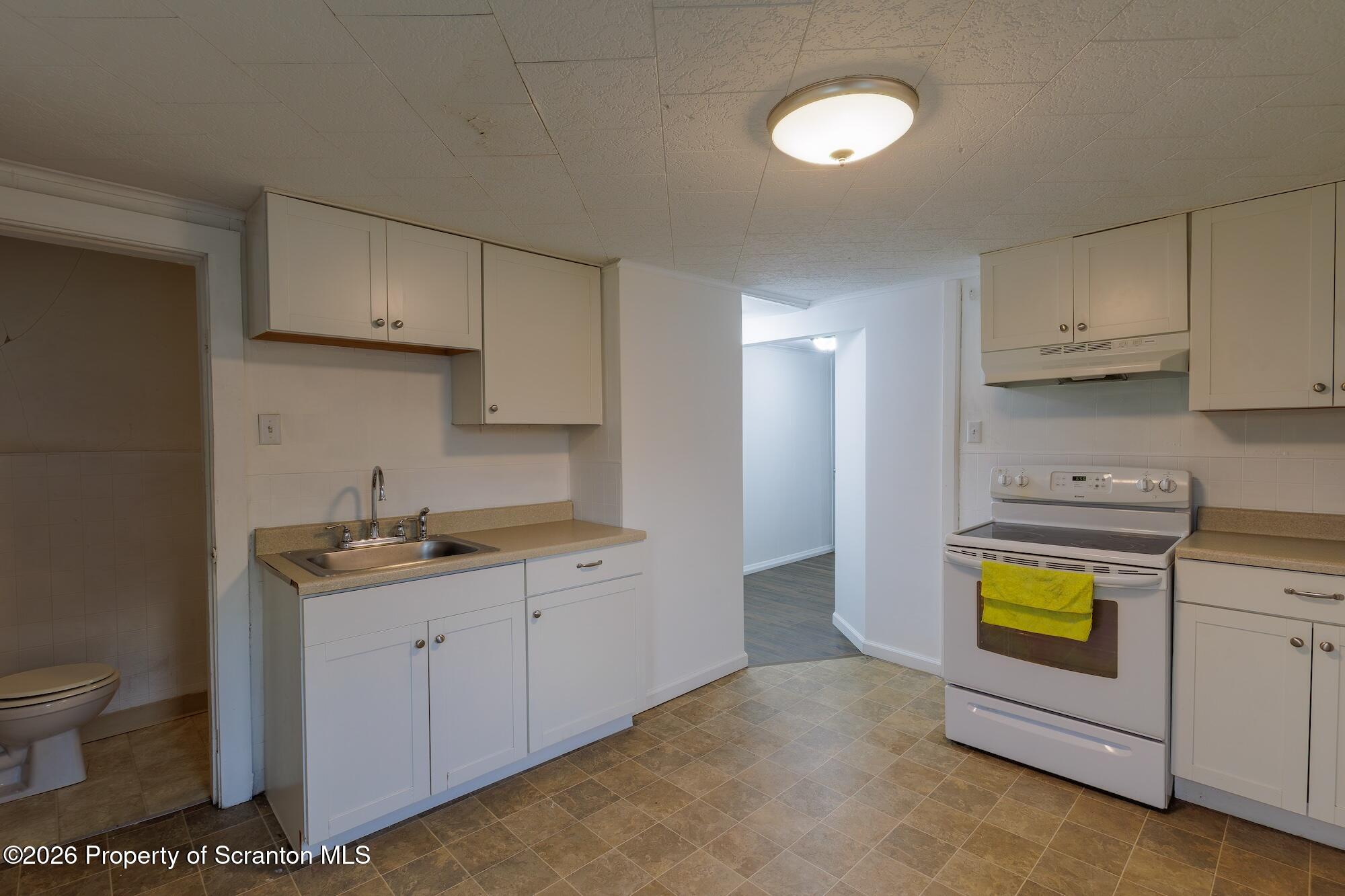 623 East Elm Street, Unit 3 Scranton, PA 18505 - Photo 11 of 18 a kitchen with stainless steel appliances a stove a sink a refrigerator cabinets and a window