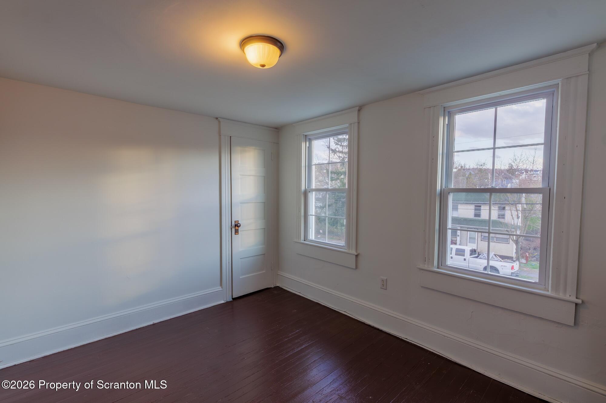 623 East Elm Street, Unit 3 Scranton, PA 18505 - Photo 6 of 18 an empty room with wooden floor and windows