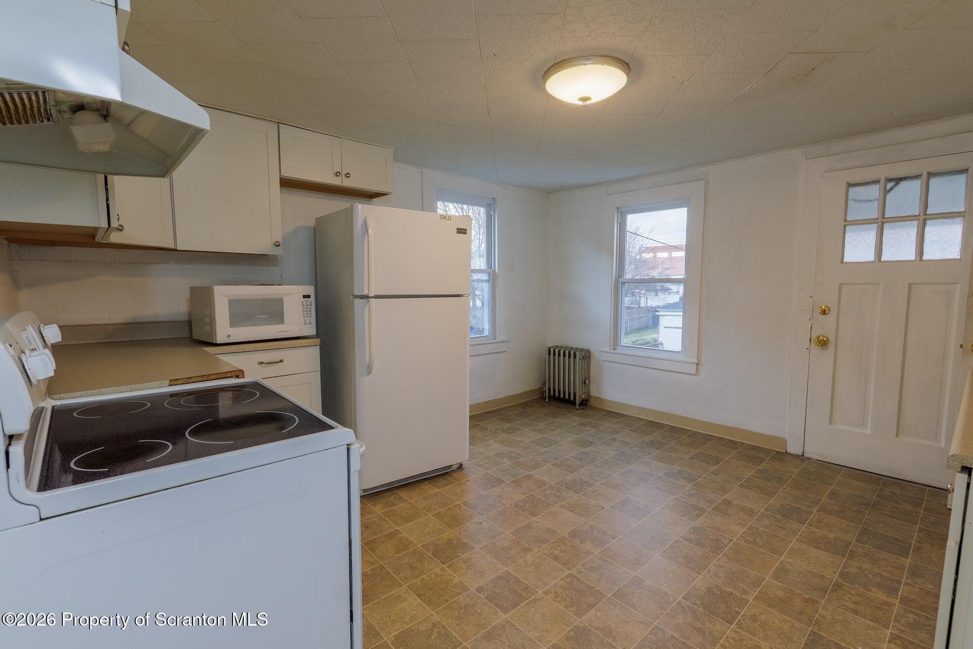 623 East Elm Street, Unit 3 Scranton, PA 18505 - Photo 9 of 18 a kitchen with a refrigerator and white cabinets