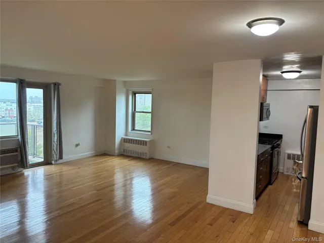 an empty room with wooden floor and a window