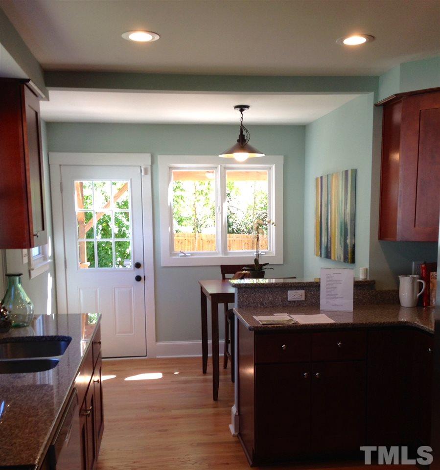 1113 Fairview Street Durham, NC 27707 - Photo 11 of 25 a kitchen with kitchen island granite countertop a sink dining table and chairs