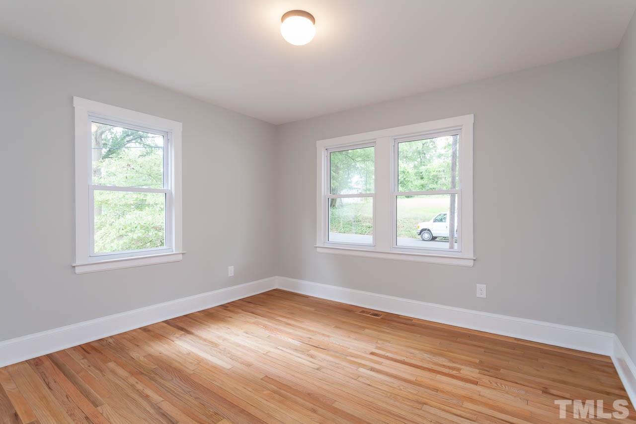 1113 Fairview Street Durham, NC 27707 - Photo 13 of 25 an empty room with wooden floor and windows